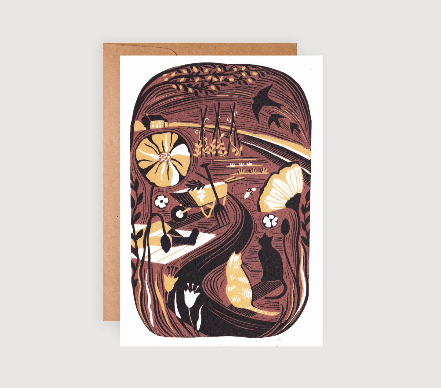 A greetings card featuring a lino print illustration of a garden scene with warm golden tones, depicting plants, veg and cats