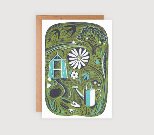 A greetings card featuring a reproduction print from an original linocut, with an illustration of a garden, including a shed, flowers, and a watering can, on an A6 size card, accompanied by a brown craft envelope.