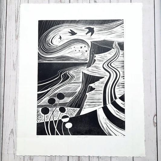 An original black and white lino print featuring a Norfolk coast path scene with birds and floral elements.