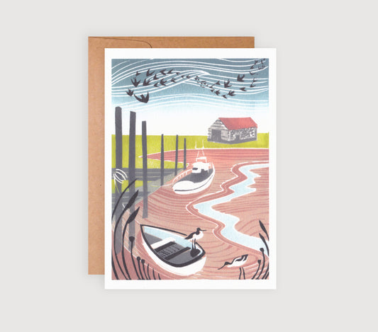 A greetings card featuring a linocut print with two avocets in the foreground and a Norfolk coastal scene in the background.