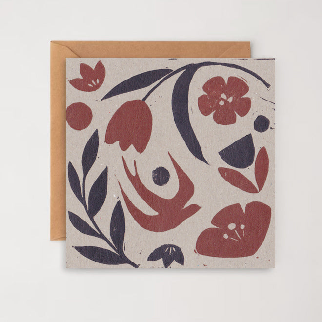 Hand printed greetings card with a floral pattern and a bird in flight, accompanied by a brown kraft envelope.