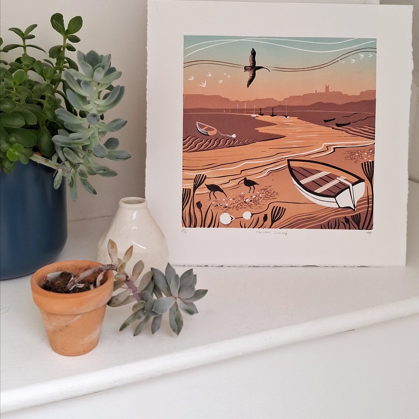 Sunset lino print on display with plants