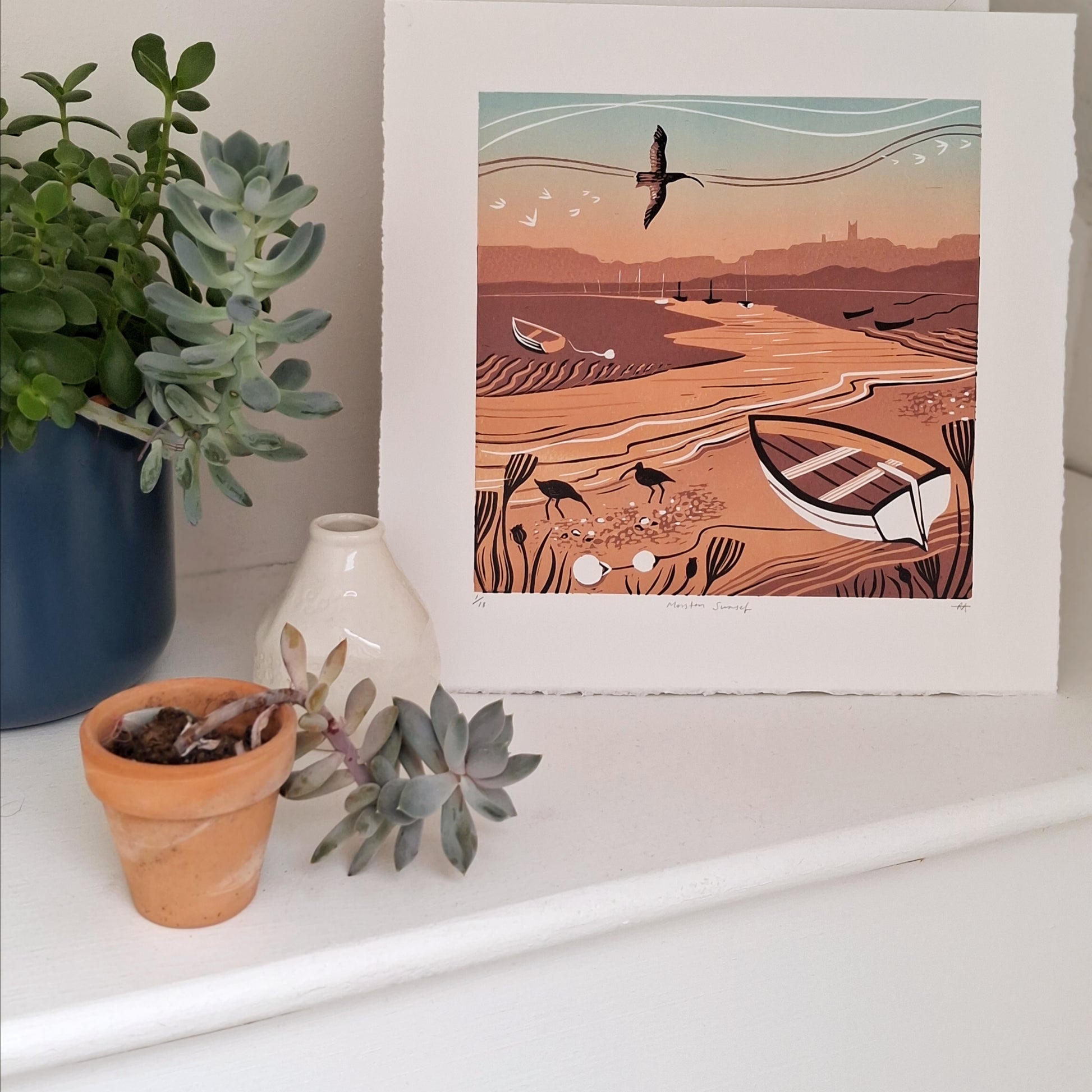 Sunset lino print on display with plants