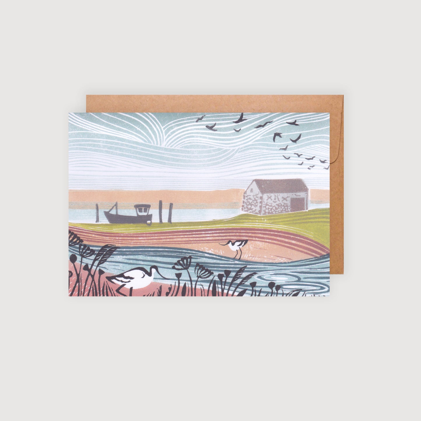 A greetings card featuring a linocut print of two avocets near a coal barn on the Norfolk coast, with a boat and flying birds in the background. The card is A6 size and includes a brown kraft envelope.